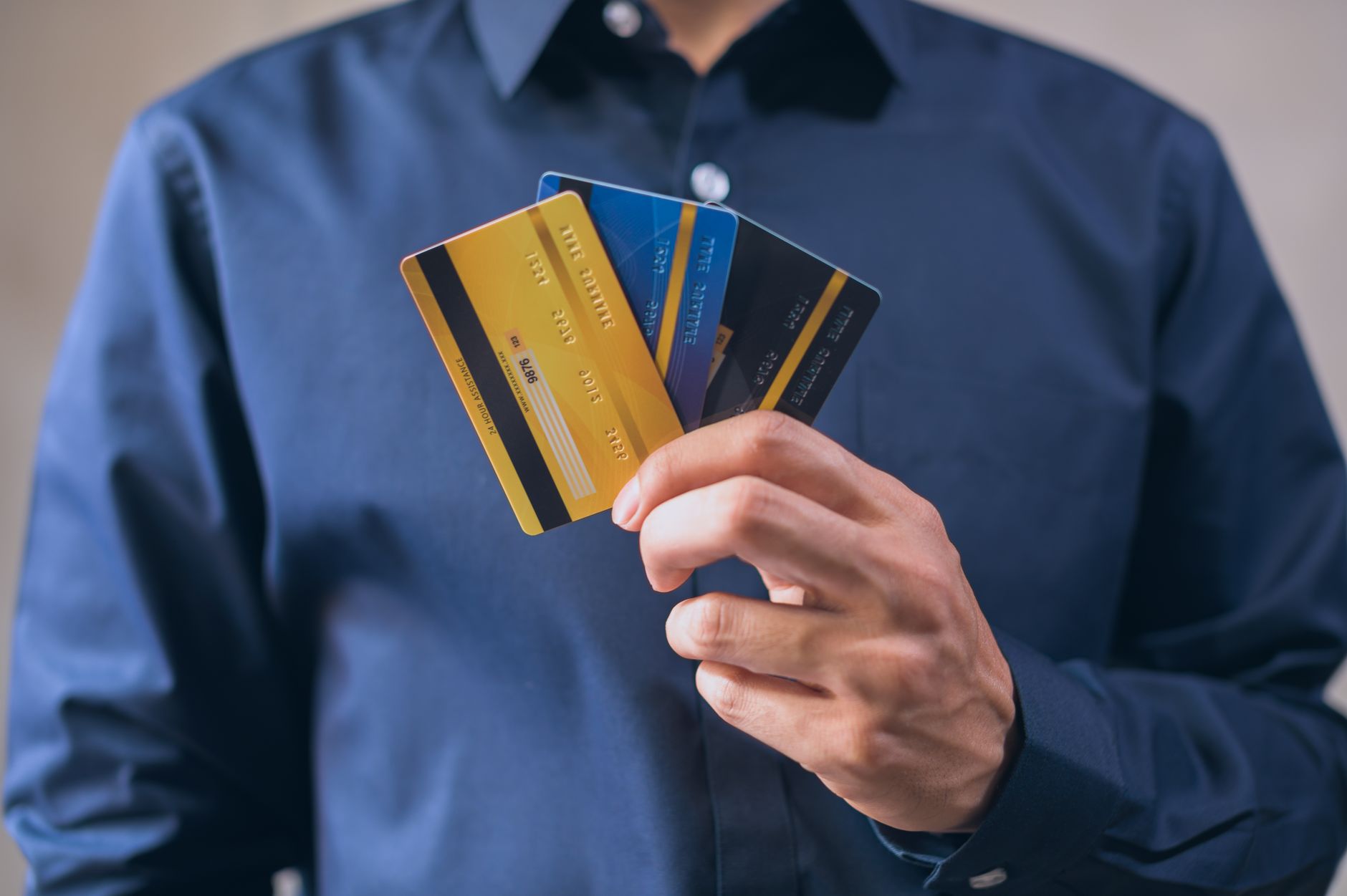 微商和社区团购怎么收款:Person holding three credit cards, symbolizing f 微商和社区团购怎么收款:Person holding three credit cards, symbolizing f